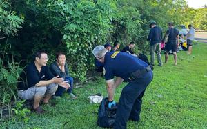 A Guam Customs and Quarantine agent speaks with Chinese nationals who allegedly tried to enter Guam illegally.