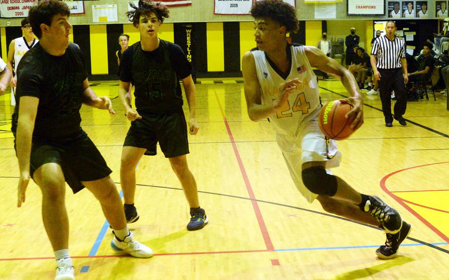 Kadena's Jeremiah Lewis dribbles against Kubasaki's Jacob Broud and Niko Arroyo during Friday's Okinawa boys basketball game. The Panthers won 43-35.