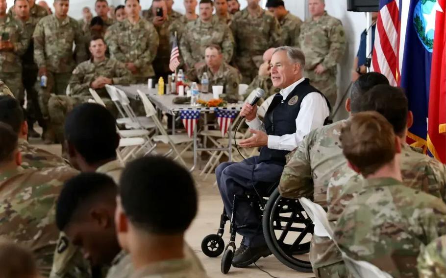 Texas Gov. Gregg Abbott meets in November with Texas National Guard troops deployed to the border with Mexico for a state mission. Abbott has pushed back against the Pentagon on a mandate for all troops to be vaccinated against the coronavirus and he said Tuesday that he intends to file a lawsuit to stop it.