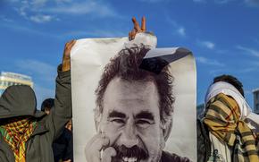 FILE - Youngsters hold a photograph of the jailed leader of the rebel Kurdistan Workers' Party, or PKK, Abdullah Ocalan as they gather to watch live on a tv screen a Pro-Kurdish Peoples' Equality and Democracy Party, or DEM, delegation members releasing an statement from Ocalan, in Diyarbakir, Turkey, Thursday, Feb. 27, 2025. (AP Photo/Metin Yoksu, File)