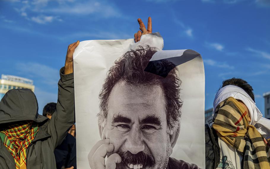 A black and white photo of Abdullah Ocalan being held up.