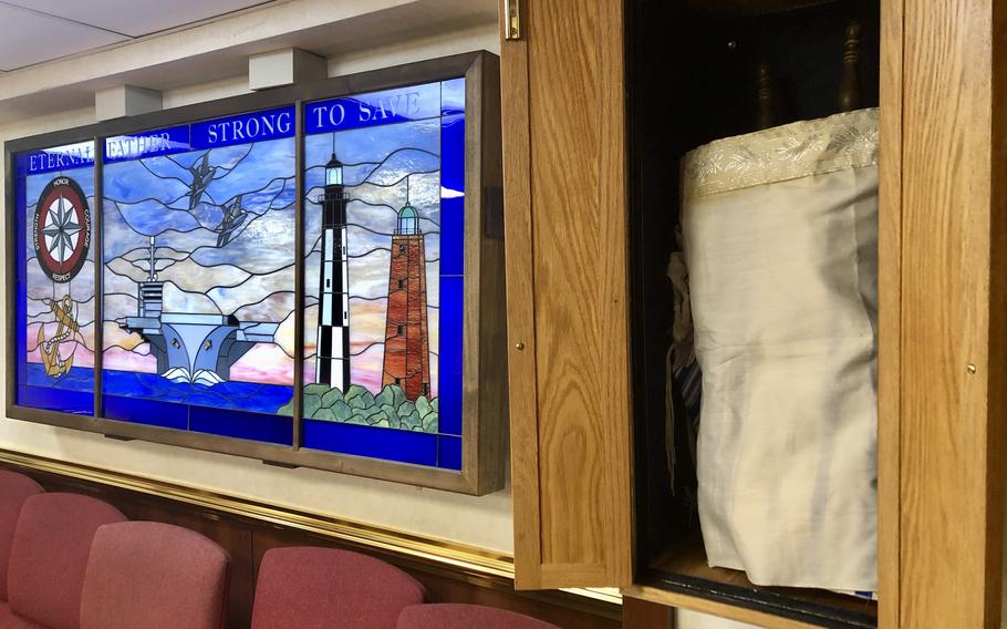 A Torah thought to be written in the 1930s is housed in a wooden cabinet, or ark, in the chapel of the aircraft carrier USS Dwight D. Eisenhower, March 19, 2024. All 11 of the Navy's aircraft carriers have Torahs on loan from the JWB Jewish Chaplains Council. The Torah, which includes the Bible, is the written text of Jewish law and teachings, and is considered to be the most sacred text of Judaism. 