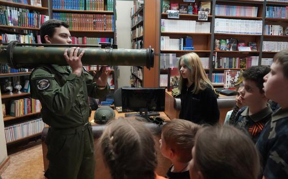 Artem, 15, demonstrates to a group of children how to carry and fire an RPG Soviet anti-tank grenade at a library session in Belgorod, Russia, on April 26. MUST CREDIT: Francesca Ebel/The Washington Post