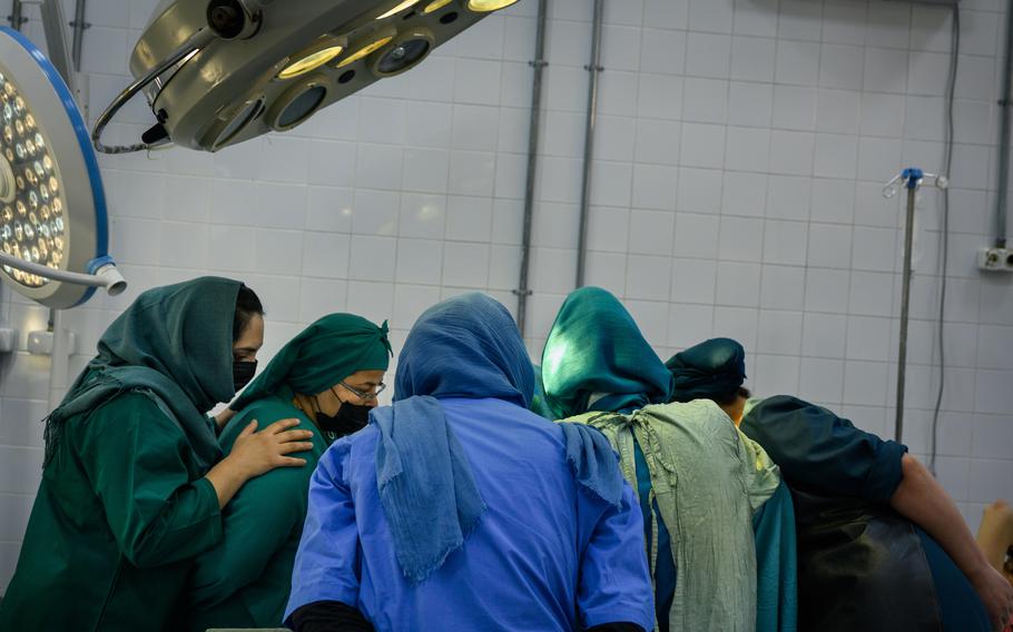 Residents watch and assist during a C-section at the Rabia Balkhi public women’s hospital, one of Kabul’s busiest, on October 23, 2022. Despite the ongoing training of 55 residents, the hospital is facing an uptick in patients which has spread the remaining doctors thin. 