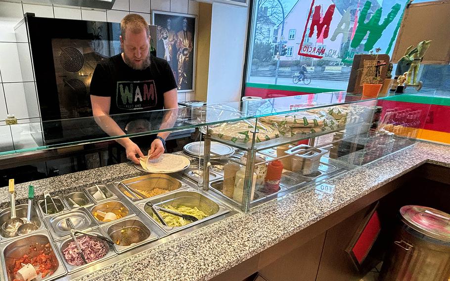 Chef Wolfgang Schlitter, owner and operator of WAM Burrito in Weiden, Germany, prepares a burrito for a customer on Feb. 12, 2024. The restaurant opened in late 2022.