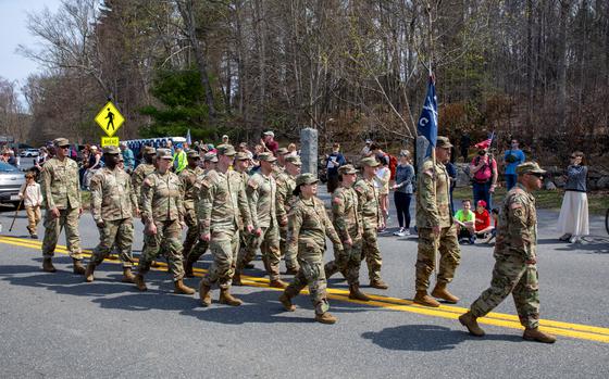 A group of soldiers march in formation on a street.