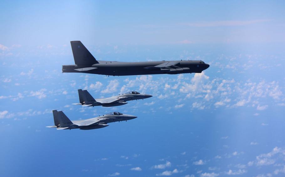 A pair of Japan Air Self-Defense Force F-15 fighters train with a U.S. Air Force B-52 Stratofortress bomber somewhere in the Indo-Pacific region, Tuesday, Aug. 31, 2021.