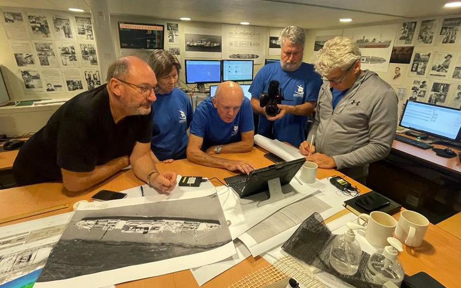 Members of the Silentworld Foundation review historical records and images of the SS Montevideo Maru in this undated photo.
