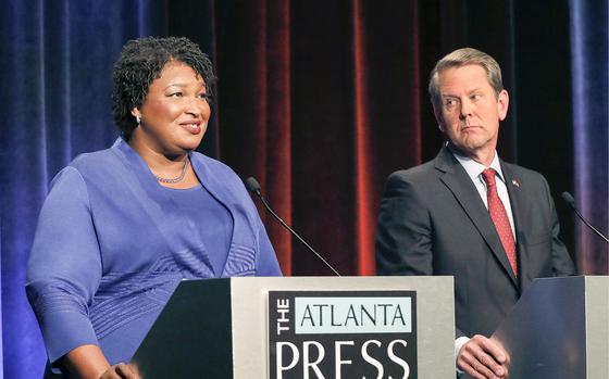 FILE - In this Tuesday, Oct. 23, 2018 file photo, Democratic gubernatorial candidate for Georgia Stacey Abrams, left, speaks as her Republican opponent Secretary of State Brian Kemp looks on during a debate in Atlanta. A federal judge says Georgia election officials must stop rejecting absentee ballots and absentee ballot applications because of a mismatched signature without first giving voters a chance to fix the problem. U.S. District Judge Leigh May on Wednesday, Oct. 24, 2018 ordered the secretary of state's office to instruct county election officials to stop the practice for the November midterm elections. She outlined a procedure to allow voters to resolve alleged signature discrepancies.(AP Photo/John Bazemore, Pool, File)