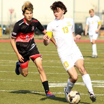 Yokota's Owen Taylor dribbles ahead of E.J. King's Joseph McGrath during Friday's DODEA-Japan soccer match. The Panthers won 6-0.