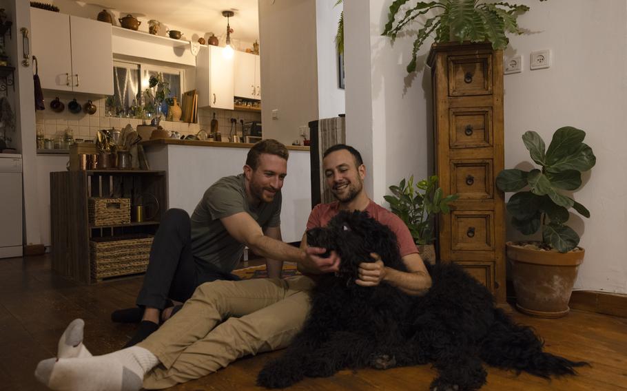 Asaf Ben-Haim, left, with his husband, David Gokhman, as they play with their dog at their home in Tal Shahar, Israel.