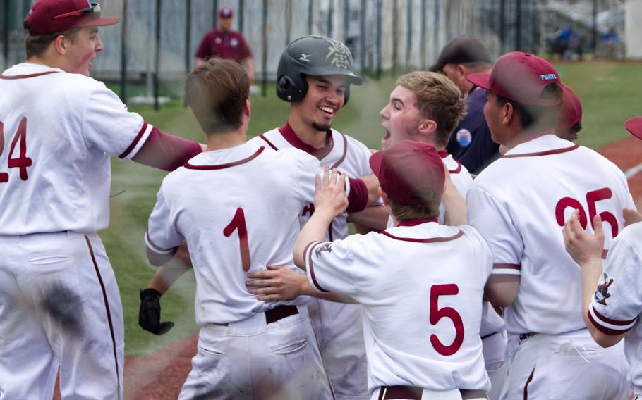 Roy Clayton III gets surrounded by his teammates celebrating Clayton's two-run homer that proved to be the game-winner as Matthew C. Perry edged Zama 3-1 during Thursday's All-DODEA-Japan baseball tournament.