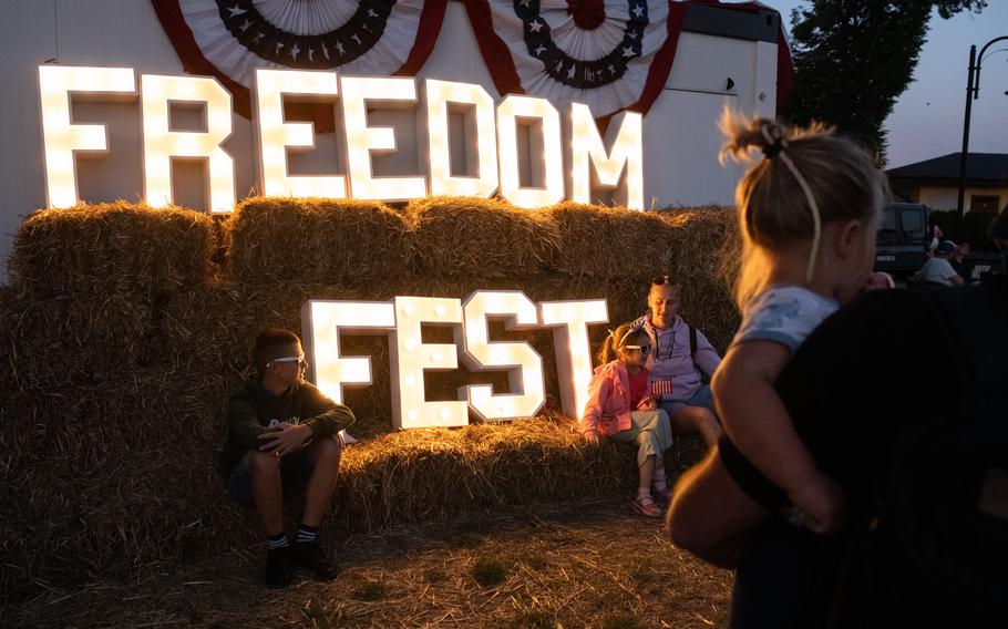 Families gather near an illuminated Freedom Fest sign.