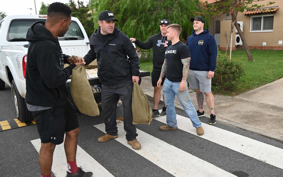 Naval Air Station Sigonella chief petty officers and chief selectees deliver sandbags to residents at base housing in preparation of an oncoming storm in Sicily, Oct. 28, 2021. Residents experienced a break from heavy rains this week, but the severe weather event is forecasted to continue battering the region.