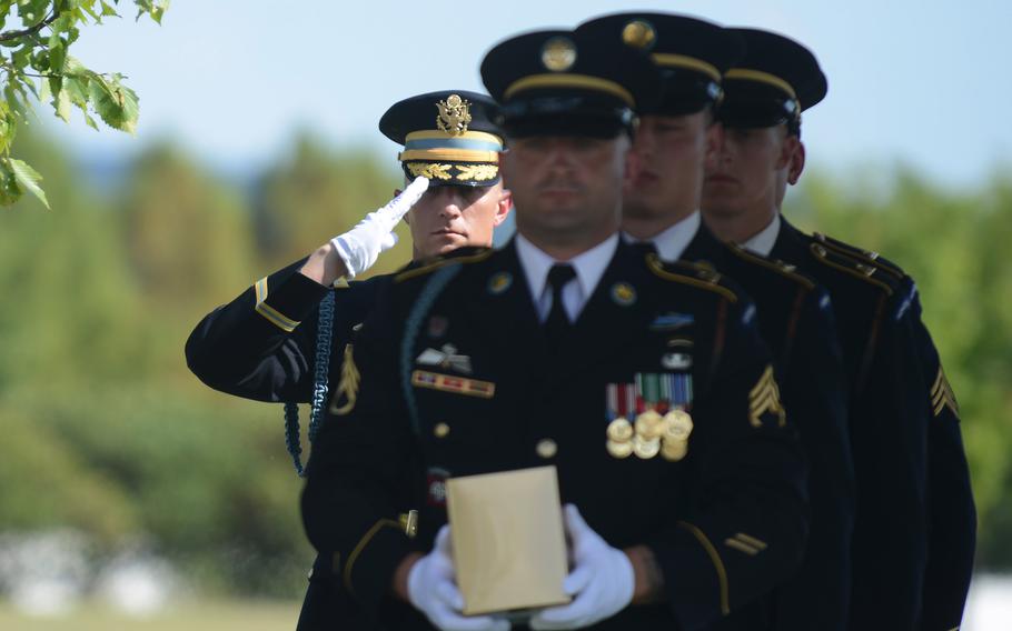 Army honor guards carry the U.S. flag and the urn of Megellas at Arlington National Cemetery on Friday, Sept. 2, 2022.