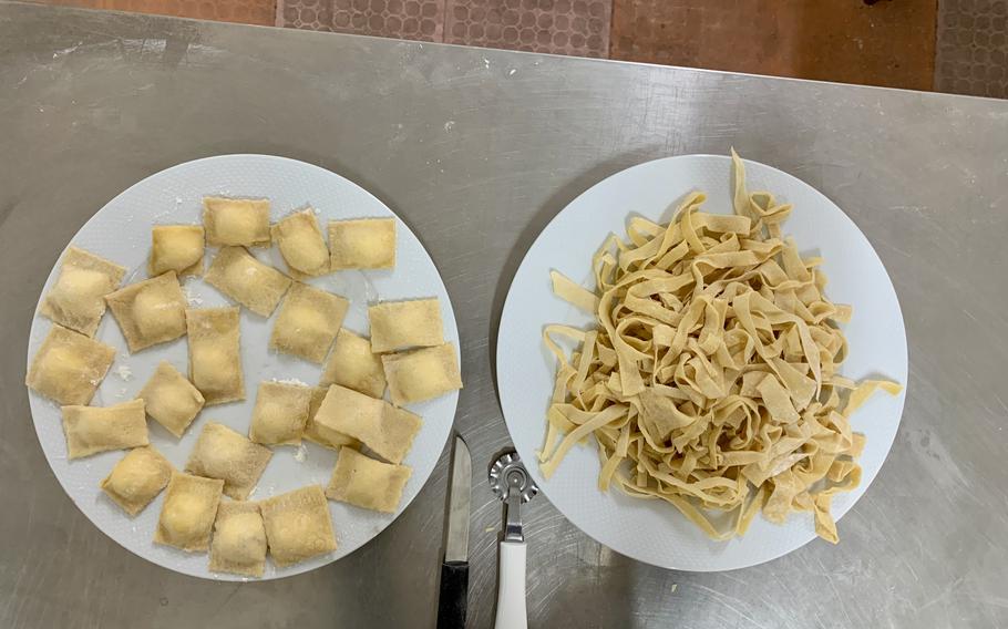 Uncooked ravioli and tagliatelle on different plates.