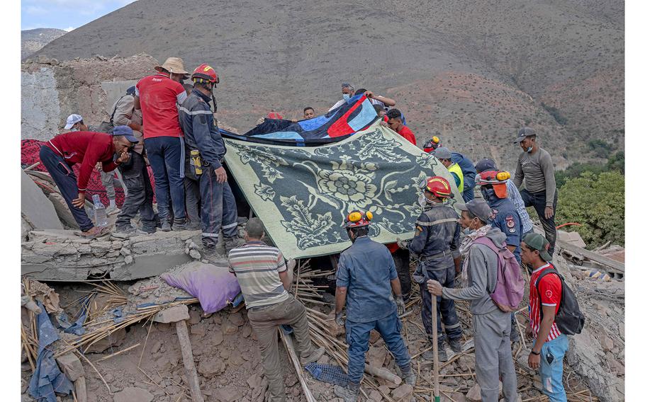 Rescue workers cover a body that was recovered from the rubble of destroyed houses in the village of Imi N'Tala, near Amizmiz, on Sept. 12, 2023, four days after the deadly 6.8-magnitude earthquake. 
