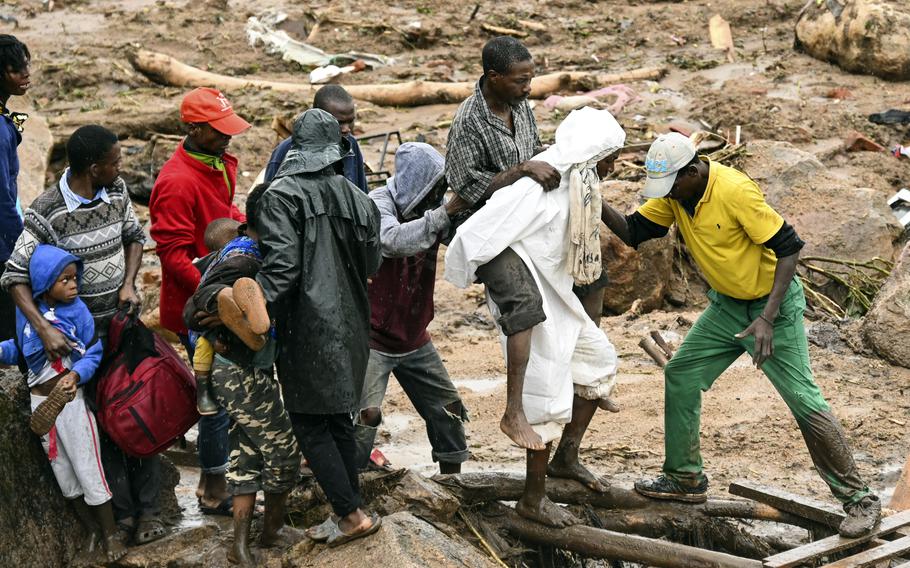 An injured man helped to safety in Blantyre, Malawi, Monday, March 13, 2023. The unrelenting Cyclone Freddy that is currently battering southern Africa has killed more than 50 people in Malawi and Mozambique since it struck the continent for a second time on Saturday night.