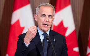 Canadian Prime Minister Mark Carney speaks with reporters.