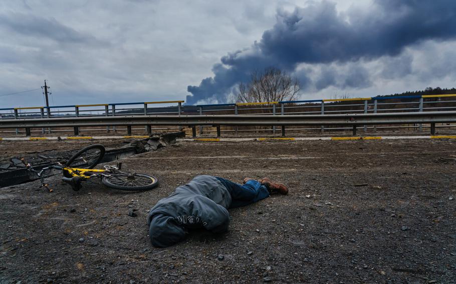A civilian body lays dead on the ground, on the destroyed bridge overlooking the Irpin River, as Russian forces continue to bombard and advance their forces, in Irpin, Ukraine, Monday, March 7, 2022.