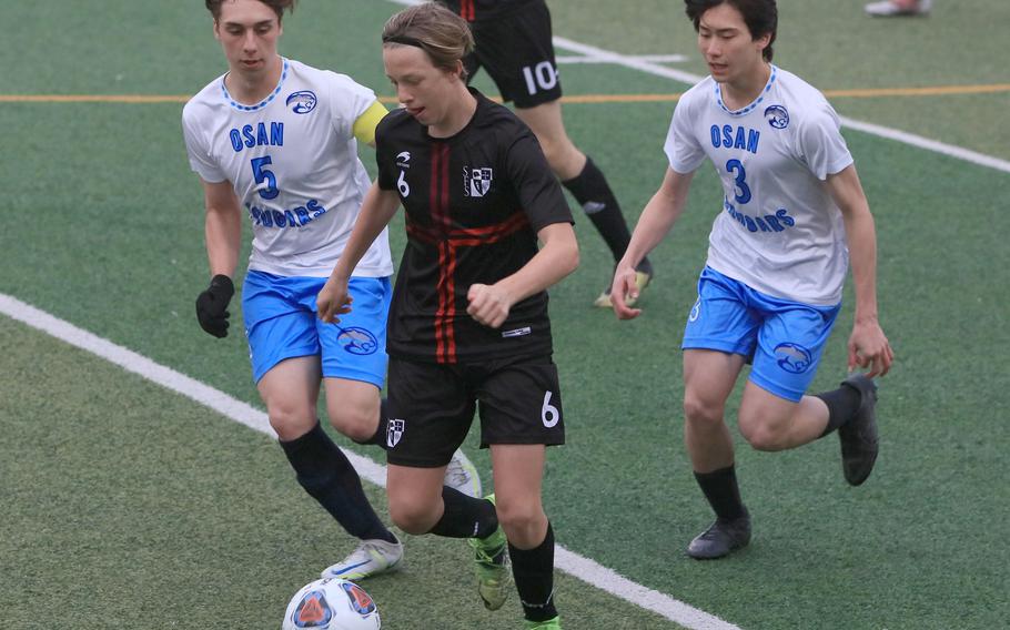 Seoul Foreign's Liam Verhaery dribbles upfield against Osan's Luigi Nasci and Ben Plouff during Wednesday's Korea boys socceer match. The Crusaders won 10-0.