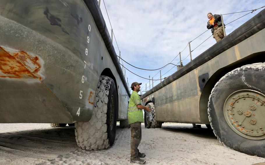 Leland Brummett talks to his sister Vashti as she stands on a Vietnam-era amphibious vehicle on Cove beach in Brigantine, Tuesday, May 24, 2022. They pulled into the Absecon Inlet after one of the two vehicles experienced steering problems.