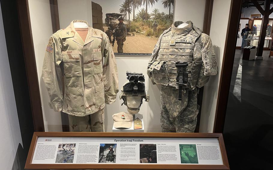 Military uniforms are on display in a museum.