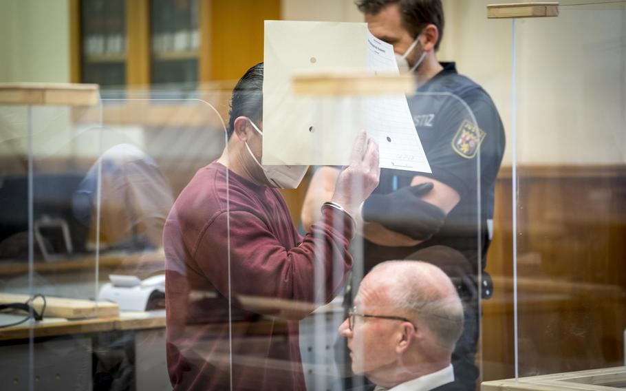 Syrian defendant Eyad Al-Gharib hides his face as he arrives to hear his verdict in a court room in Koblenz, Germany, Wednesday, Feb. 24, 2021. Germany’s top court said Tuesday, May 3, 2022 that it has rejected the appeal of a former members of Syria’s secret police who was convicted last year of facilitating the torture of prisoners in his home country.