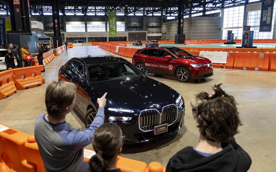 People look at electric BMWs and Volkswagens on the test track at the Chicago Auto Show on Sunday, Feb. 12, 2023, at McCormick Place in Chicago. 