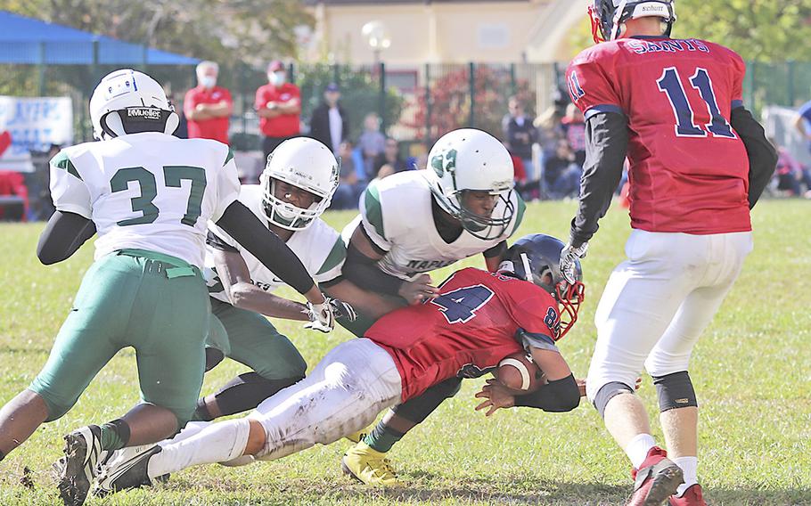 Aviano’s Colin North gets tackled by Naples Wildcats defenders during Saturday’s football game held at Aviano. The Wildcats won the game decisively by the score of 40-0.