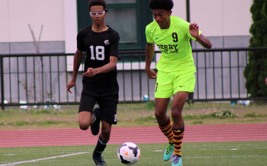 Perry’s Jalen Cooley and Daegu’s Alaxander Kenny chase the ball during Tuesday’s boys Division II soccer match. The Samurai won 1-0.