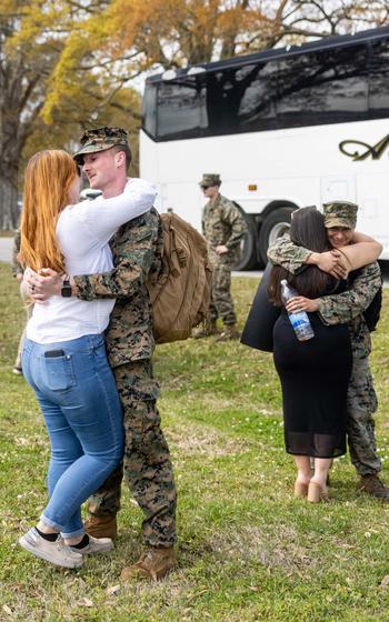 U.S. Marine Corps Cpl. Gustavo Baxton (left), and Cpl. Nahson Aboytes (right), with the 26th Marine Expeditionary Unit (Special Operations Capable) embrace their loved ones after returning from deployment with the 26th MEU, Camp Lejeune, N.C., Sunday, March 17, 2024.