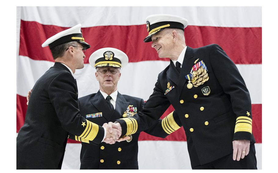Incoming Vice Adm. Douglas Perry, left, shakes hands with Vice Adm. Daniel Dwyer after relieving him of his duties in a change of command ceremony aboard the aircraft carrier USS Harry S. Truman at Naval Station Norfolk on Jan. 12, 2024. 
