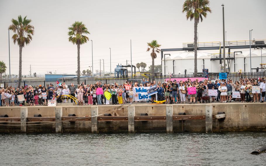 Families wait portside.
