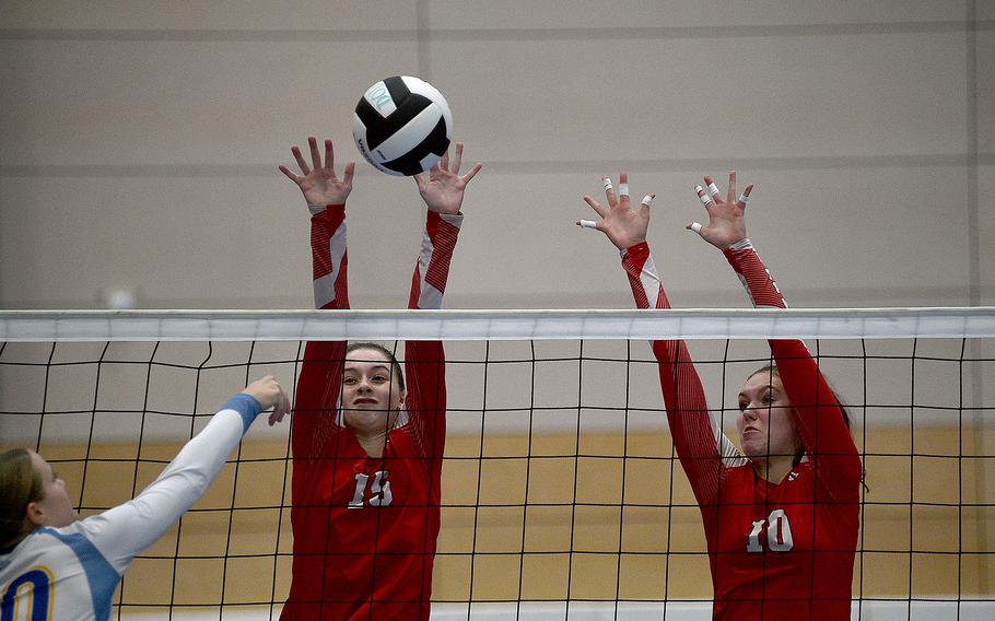 Kaiserslautern's Roz Onnen, left, and Mariska Campbell go up to block an attack by Wiesbaden's Rylee Ashcraft during pool-play action of the DODEA European volleyball championships on Oct. 26, 2023, at Ramstein High School on Ramstein Air Base, Germany.