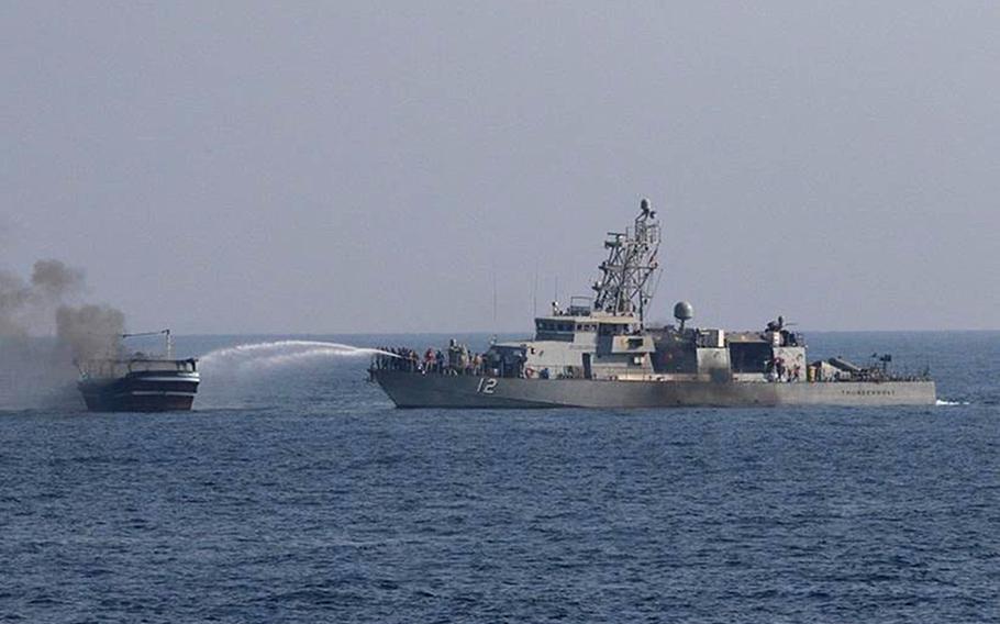 Sailors aboard patrol coastal ship USS Thunderbolt extinguish a fire aboard a fishing vessel in the Gulf of Oman, Oct. 29, 2022. The vessel, found to be smuggling drugs, was set on fire by the crew as U.S. forces approached, the Navy said. 