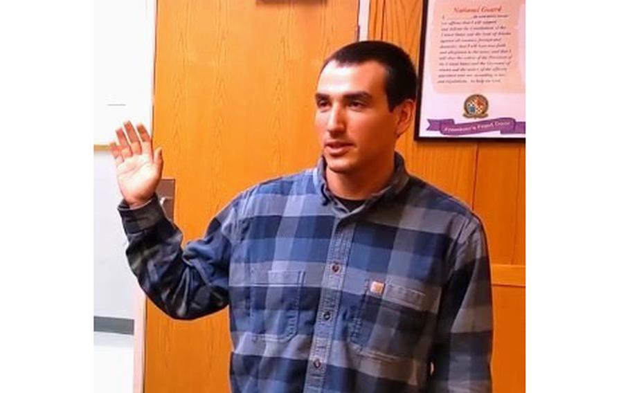 Evan Huettl takes the oath to join the Army at the Anchorage Military Entrance Processing Station in Alaska on Oct. 14, 2021. 