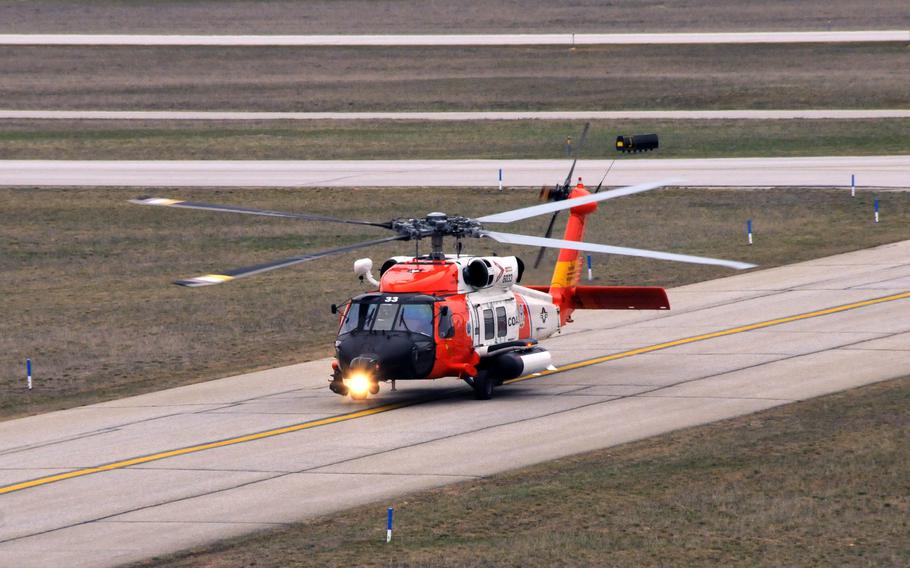A Coast Guard helicopter taxis on the runway.