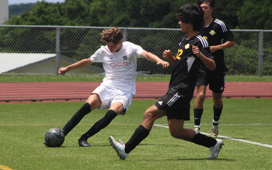 OCSI's Stani Marynowski outraces Kadena's William Wetheril for the ball.l  