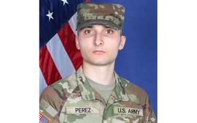 Perez in an official Army photo wearing fatigues with an American flag behind him.