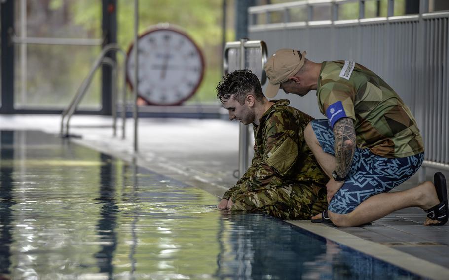 German air force Senior Master Sgt. Benjamin Angel, a training NCO with NATO Allied Air Command, talks with U.S. Air Force Senior Airman Robert Johnson, a radio technician with American Forces Radio, following the swim portion of the German Armed Forces Badge for Military Proficiency in time at Ramstein Air Base, Germany, April 22, 2024.