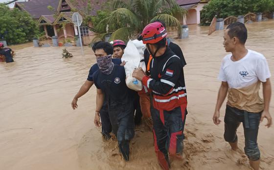 In this photo released by the Wajo Regional Disaster Management Agency (BPBD Wajo), rescuers carry a victim of a flood in Wajo, South Sulawesi, Indonesia on May 3, 2024.