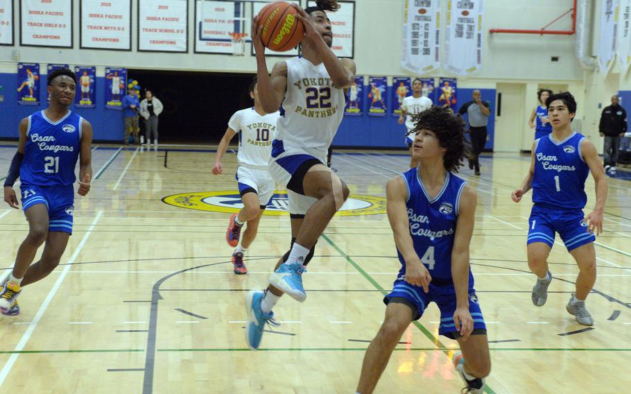 Boys D-II tournament MVP Marcus Woods of Yokota drives past Osan's Travus Boyd.