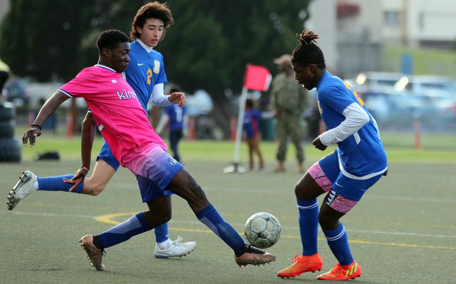 Nile C. Kinnick’s Koboyo Awesso tries to settle the ball between Yokota’s Tommy Vogeley and Jai Bailey during Thursday’s DODEA-Japan/Kanto Plain boys soccer match. The Red Devils won 2-0.