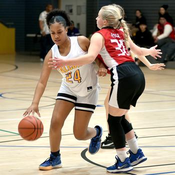 Bahrain's Naava Barber dribbles while American Overseas School of Rome's Clara Clayton defends during pool-play action at the Division II DODEA European Basketball Championships on Wednesday at Southside Fitness Center on Ramstein Air Base, Germany.