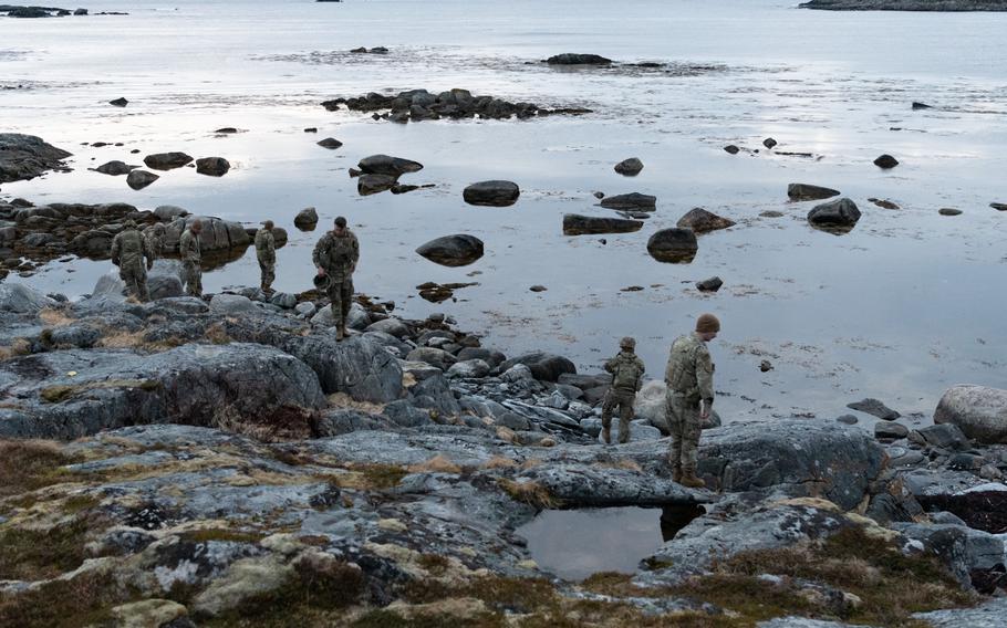 Soldiers stand on shore.