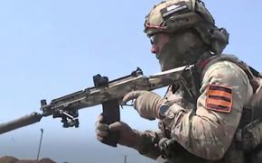A Russian soldier holds his rifle against his shoulder.