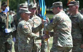 Soldiers hold onto a flag during a change of command.
