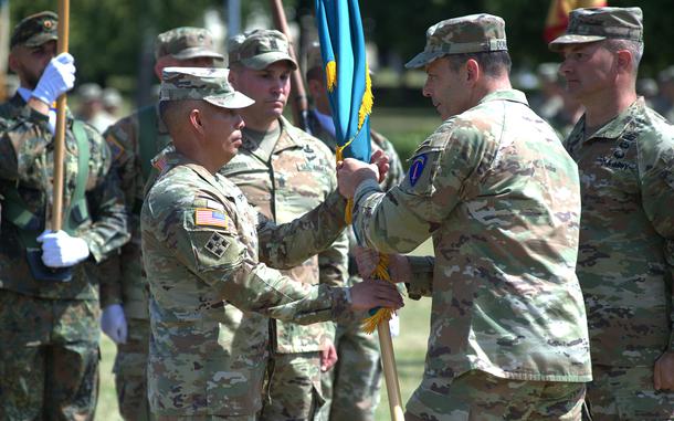 Soldiers hold onto a flag during a change of command.