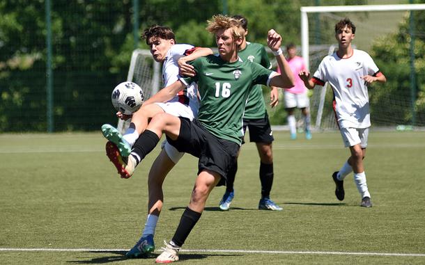 Naples midfielder Colin McCord and American Overseas School of Rome winger Ghione Federico fight for possession during the first day of pool-play action at the 2025 Division II DODEA European championships at the stadium of VfB Reichenbach on May 19, 2025, in Reichenbach-Steegen, Germany.